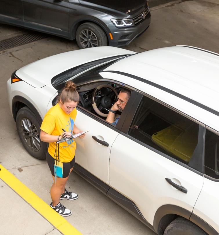 Car pulling up to garage and speaking with coordinator