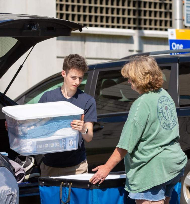 Parents helping student unload belongings from car