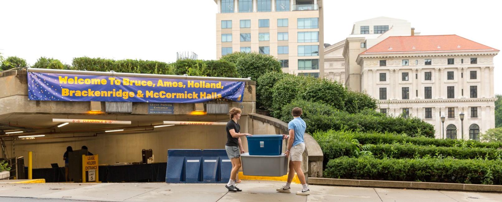 Students carrying container through campus